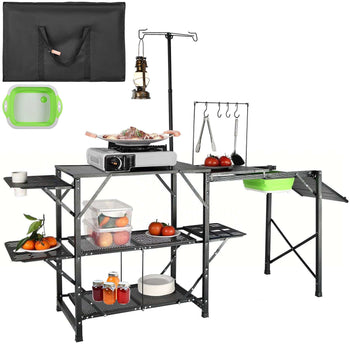 Black portable camping kitchen with shelves, green utensils, lantern, and food prep area for outdoor cooking.
