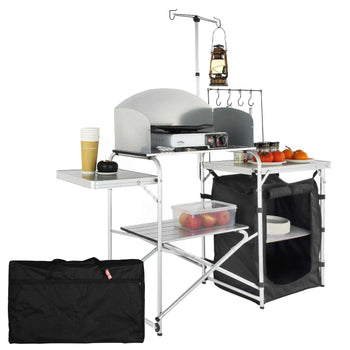Compact outdoor cooking station in silver and black, featuring foldable tables, storage, and a durable carry bag.