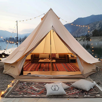 Cream canvas bell tent with cozy seating, outdoor rugs, and string lights, perfect for glamping or stylish camping.
