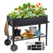 Black metal garden cart planter with vegetables, gardening tools, and accessories on wheels for easy mobility.