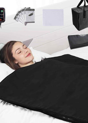 Black electric heating blanket with controller, cozy design, includes storage bag, ideal for warmth and relaxation.