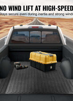 Black truck bed liner with ridged texture, ensuring cargo stability at high speeds, on a road background.