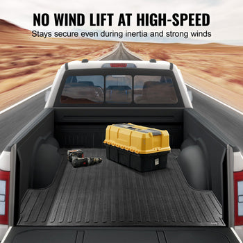 Black truck bed liner with ridged texture, ensuring cargo stability at high speeds, on a road background.