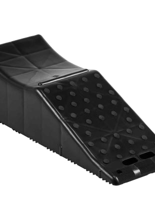 Black ergonomic footrest with a textured surface and a sloped design for improved posture and comfort.