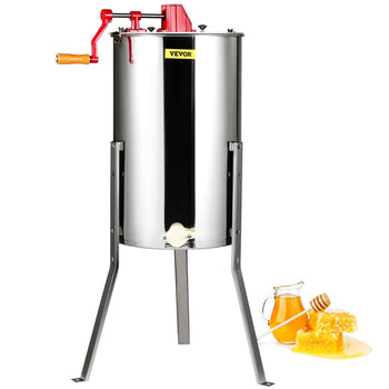 Stainless steel honey extractor with red handle, sturdy legs, and honey jar with honeycomb beside it.
